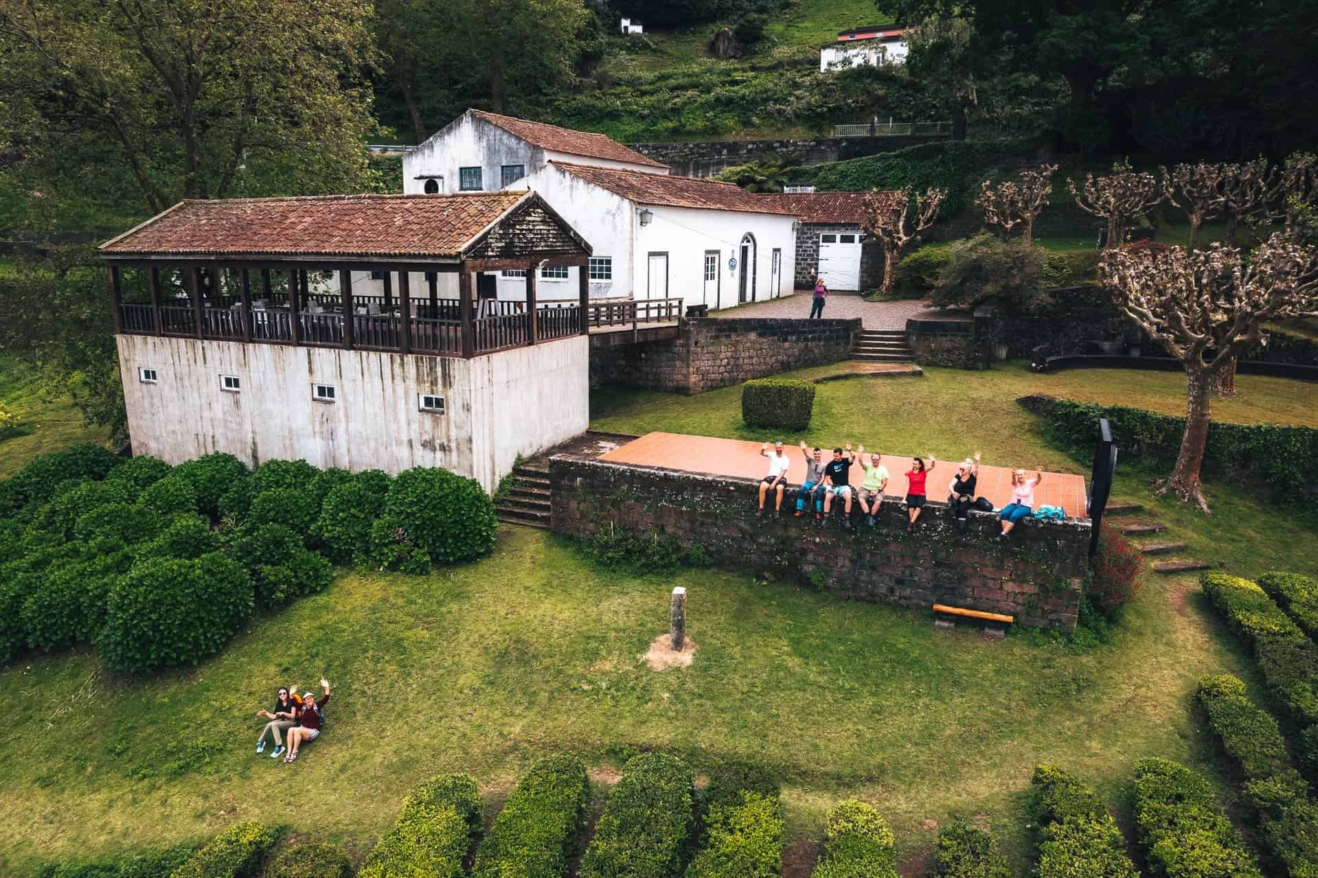 Skupina turistů odpočívající u budovy čajové plantáže Chá Porto Formoso, Sao Miguel, Azory